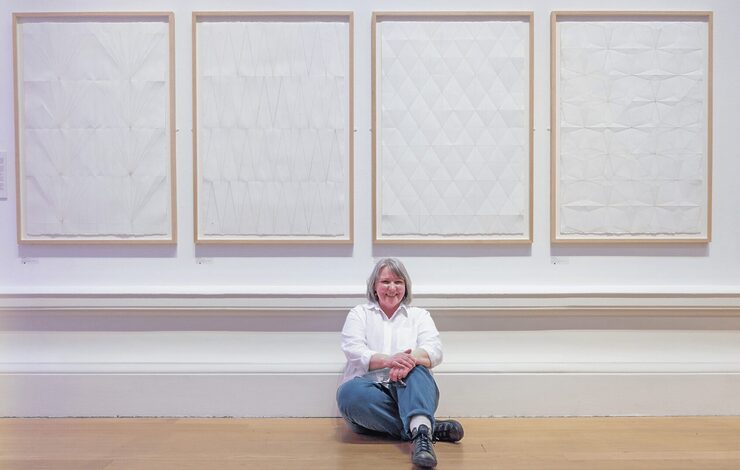 Charlene Scott RSA Tonic Arts Graduate Prize winner sat on the floor underneath her four artworks