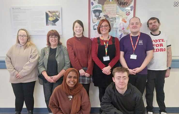 patients and staff standing in front of artwork