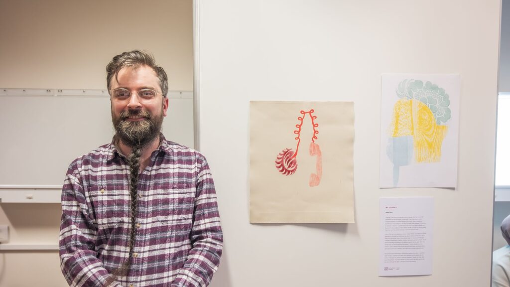 a patient standing in front of their artwork