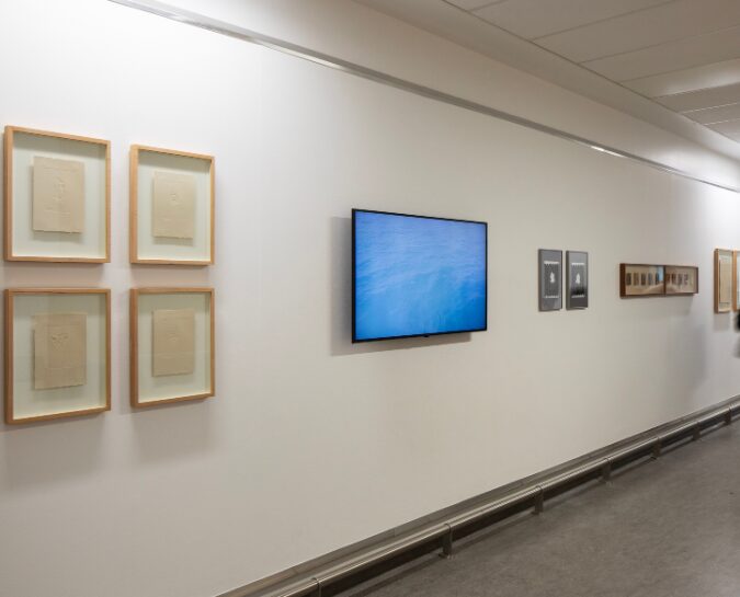 Daniele Sambo's Artwork on wall with TV showing video of him