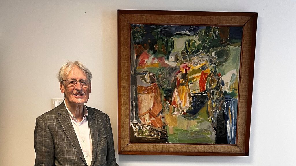 Dr Duncan Thomson standing beside his artwork: Across the Land