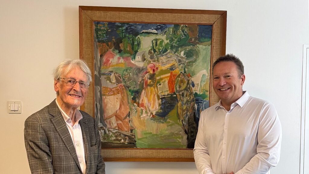 Dr Duncan Thomson standing beside his artwork: Across the Land with Hospital Director Chris Stirling