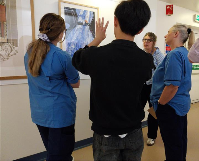 staff discussing art on a wall