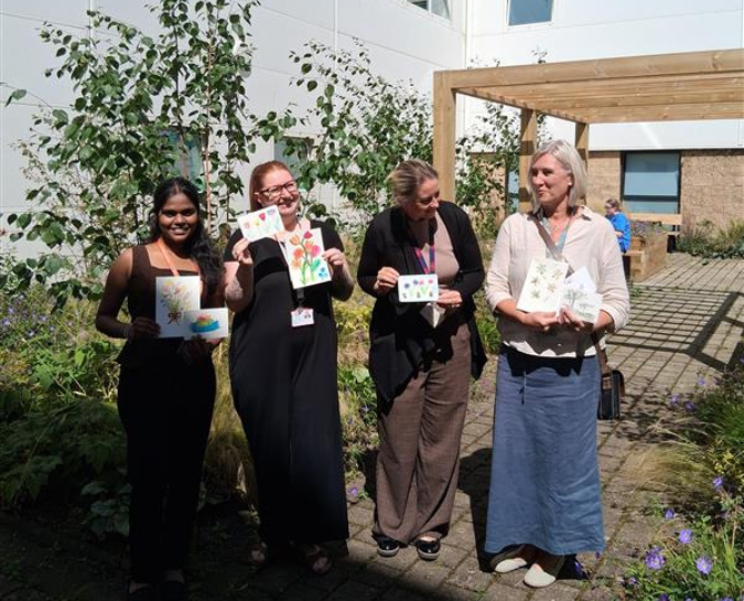 staff holiding their artworks outside