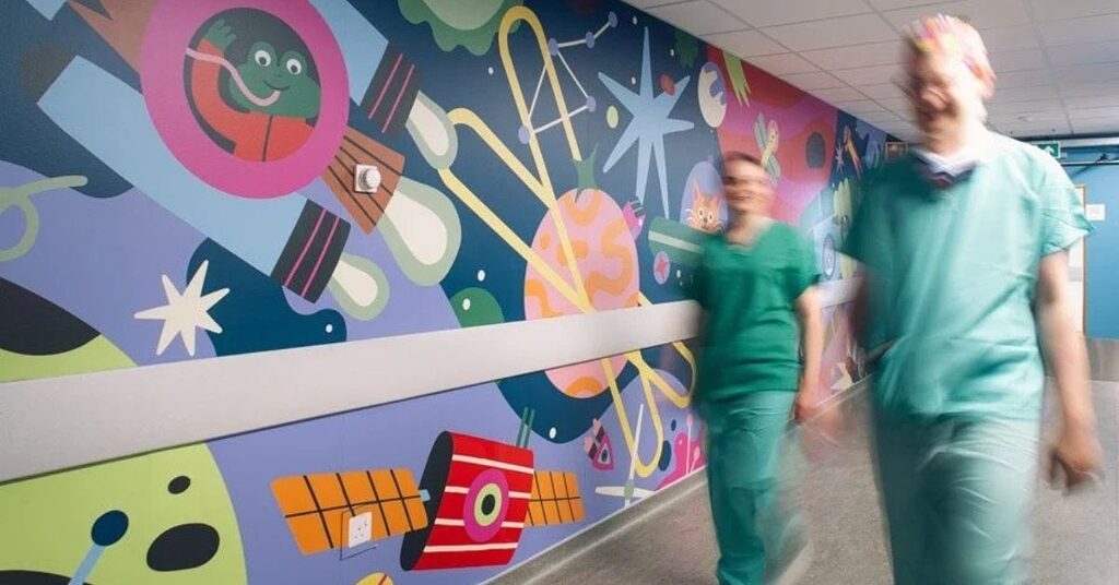 staff passing by artwork
