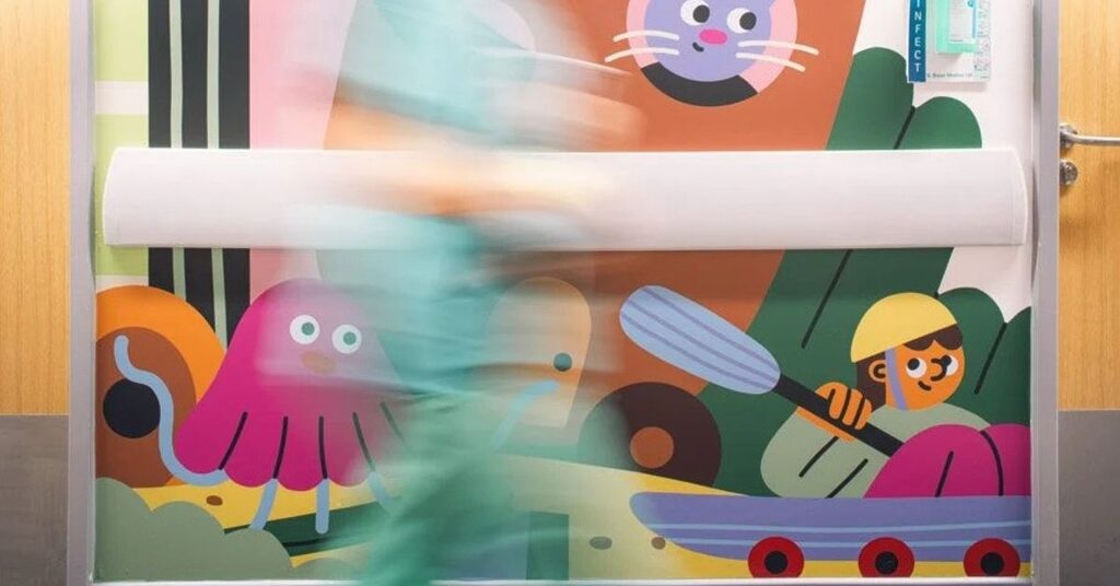 staff walking past artwork