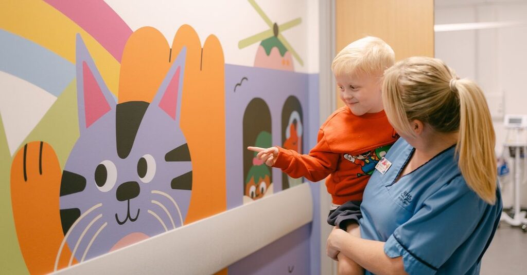 child and nurse pointing at art
